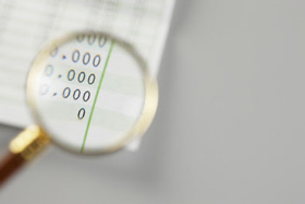 節税対策をイメージした虫眼鏡で数値を拡大している写真